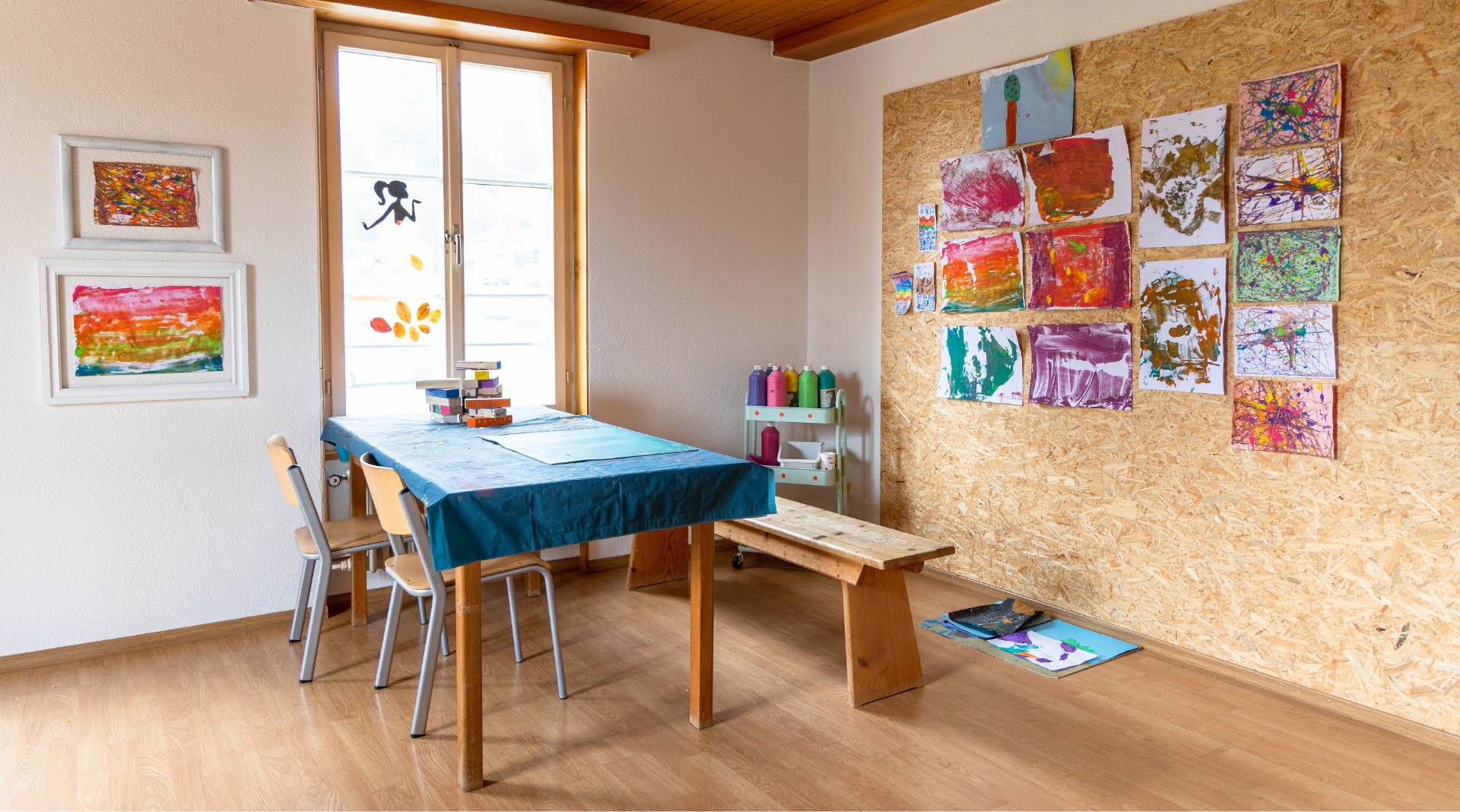 Malzimmer mit Tisch zum malen und Wand mit Bilder in den Tagesstrukturen Menziken