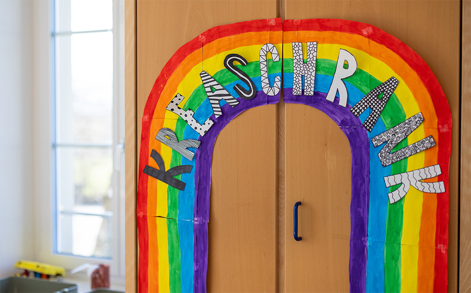 Bunter Regenbogen mit Schriftzug „Klaschrank“ im Gruppenraum der Tagesstrukturen Würenlos